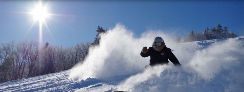 stratton mountain skier powder blue sky